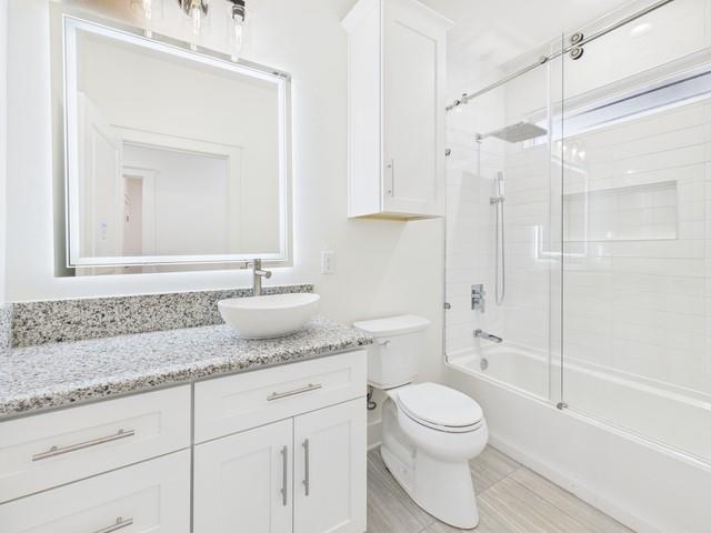 511 Richardson Street Athens, TX 75751 - Photo 23 of 40 a bathroom with a granite countertop sink toilet a shower and a mirror