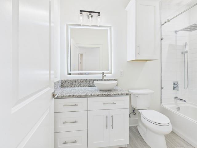 511 Richardson Street Athens, TX 75751 - Photo 32 of 40 a bathroom with a granite countertop toilet sink and mirror
