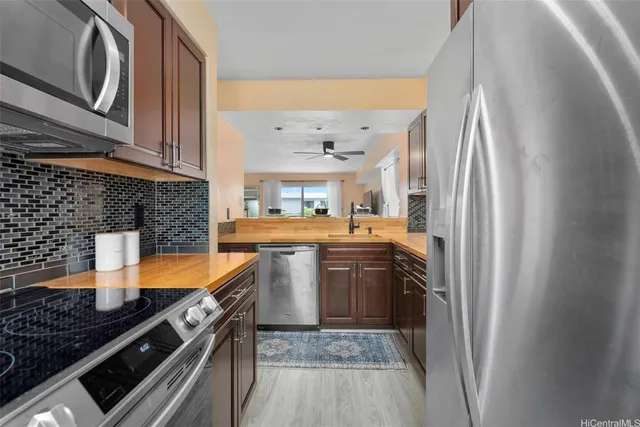 a kitchen with stainless steel appliances granite countertop a refrigerator and a stove