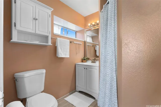 a bathroom with a toilet a sink and mirror