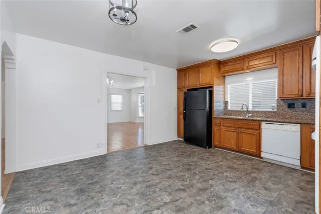 a kitchen with a refrigerator and a stove top oven