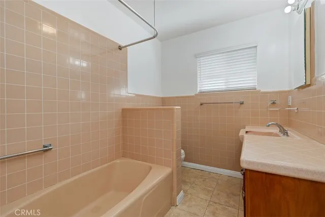 a bathroom with a sink a bathtub and a window