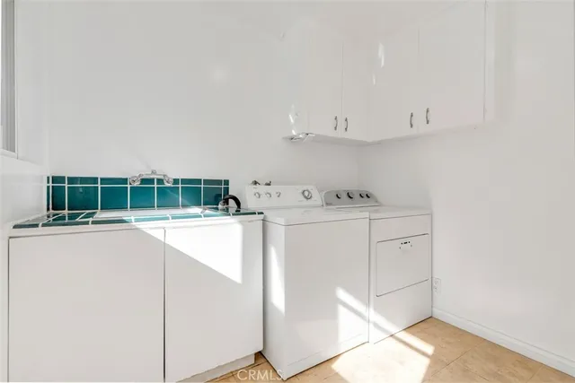 a utility room with cabinets washer and dryer
