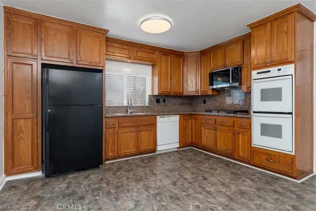 a kitchen with granite countertop stainless steel appliances and refrigerator