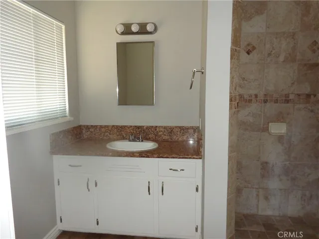 a bathroom with a granite countertop shower