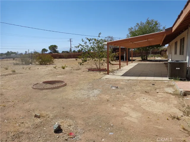 a view of a dry field with mountains in the background
