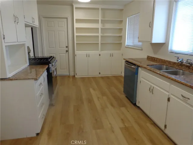 a kitchen with granite countertop white cabinets and appliances