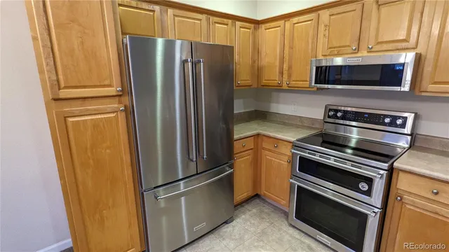 a kitchen with stainless steel appliances and refrigerator