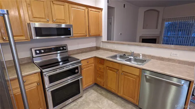 a kitchen with stainless steel appliances a sink a stove a microwave a sink and cabinets