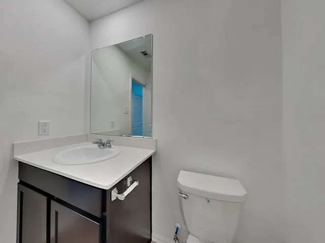 a bathroom with a sink toilet and mirror