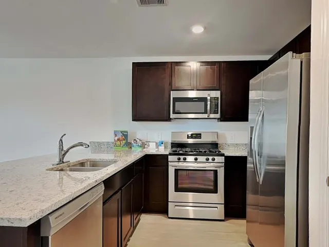 a kitchen with a sink stove and refrigerator