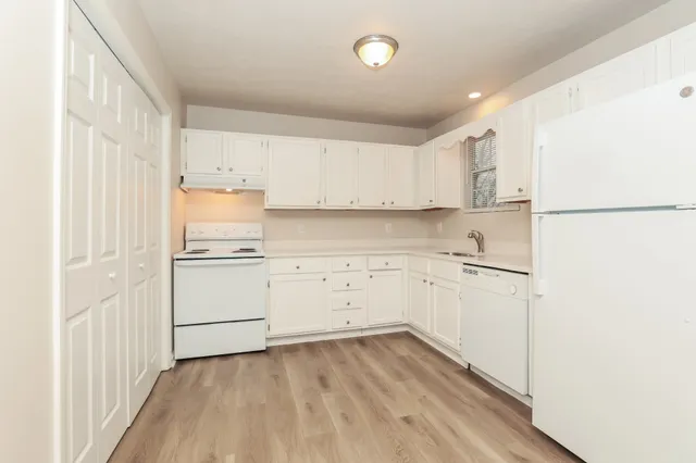 a kitchen with white cabinets and white appliances