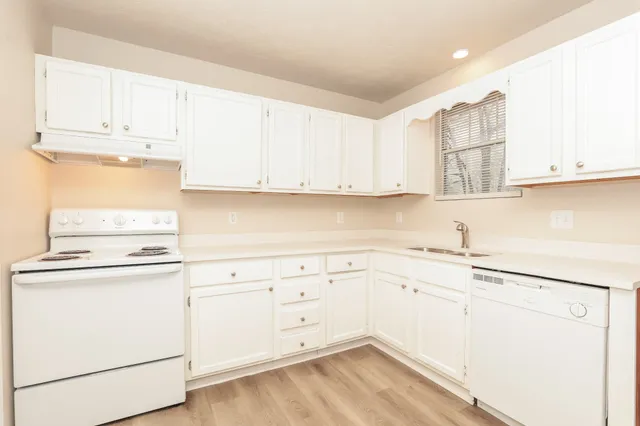 a kitchen with granite countertop white cabinets and white appliances