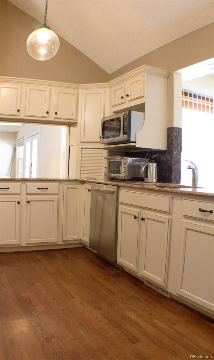 3596 South Telluride Way Aurora, CO 80013 - Photo 4 of 17 a kitchen with stainless steel appliances granite countertop a sink and cabinets