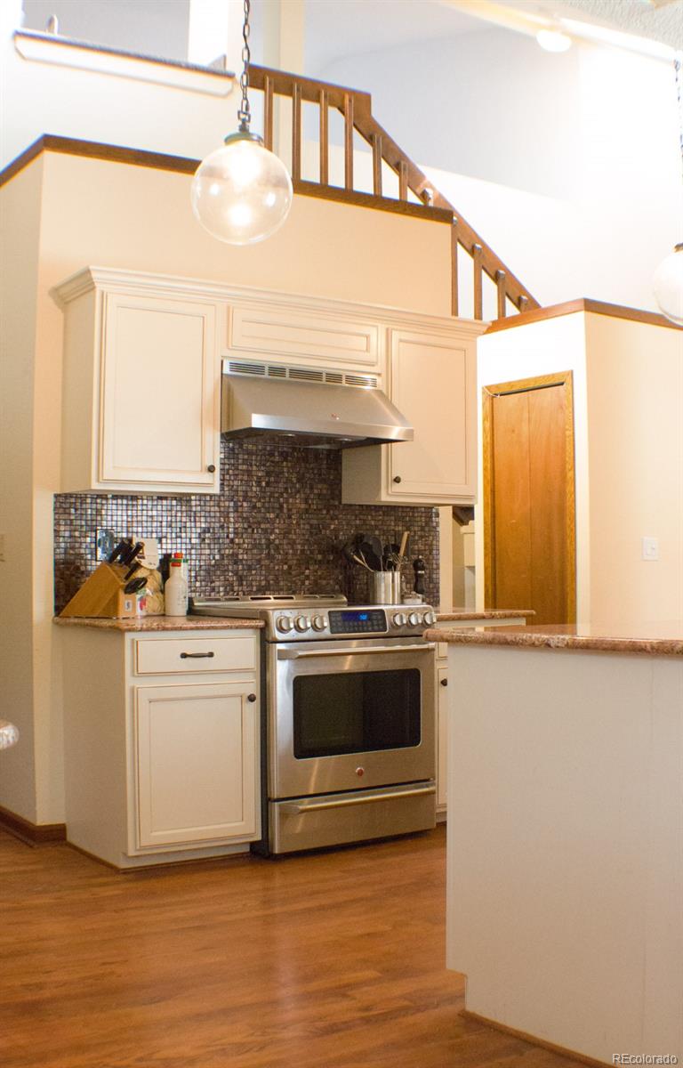 3596 South Telluride Way Aurora, CO 80013 - Photo 5 of 17 a kitchen with stainless steel appliances granite countertop a stove and white cabinets
