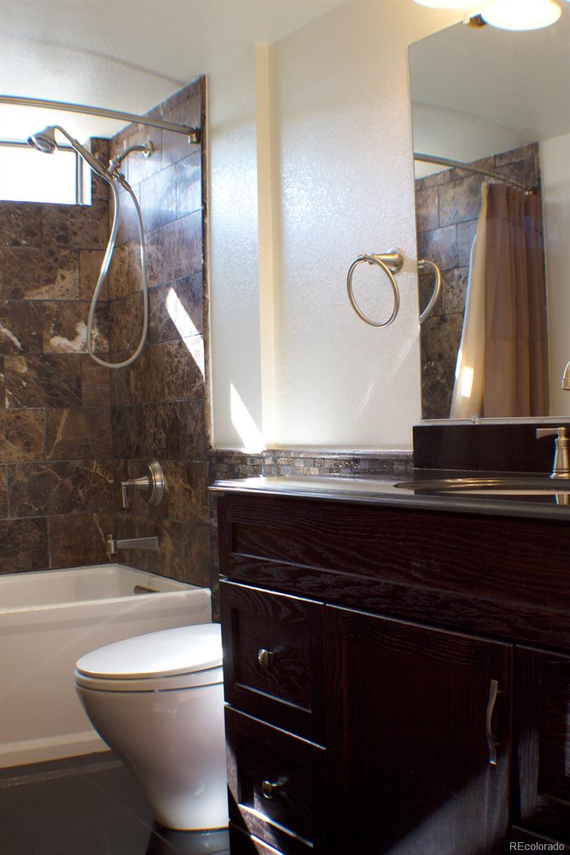 3596 South Telluride Way Aurora, CO 80013 - Photo 9 of 17 a bathroom with a sink a toilet and shower