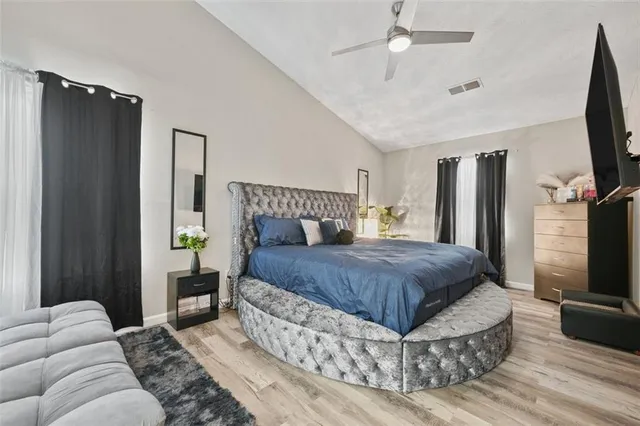 a bedroom with a bed flat screen tv and a couch