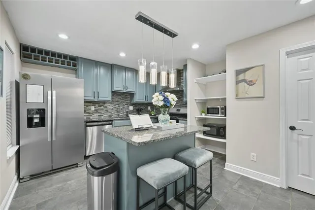a kitchen with stainless steel appliances granite countertop a refrigerator and a stove top oven