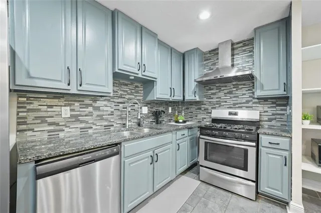 a kitchen with stainless steel appliances granite countertop a stove sink and cabinets