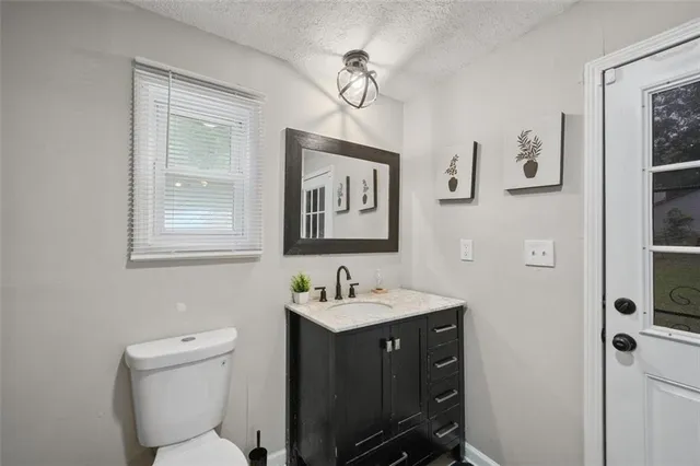a bathroom with a toilet a sink and mirror