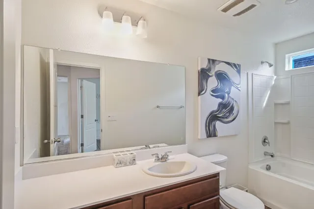 a bathroom with a sink vanity mirror and toilet