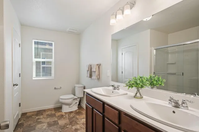 a bathroom with a granite countertop sink a toilet and a mirror