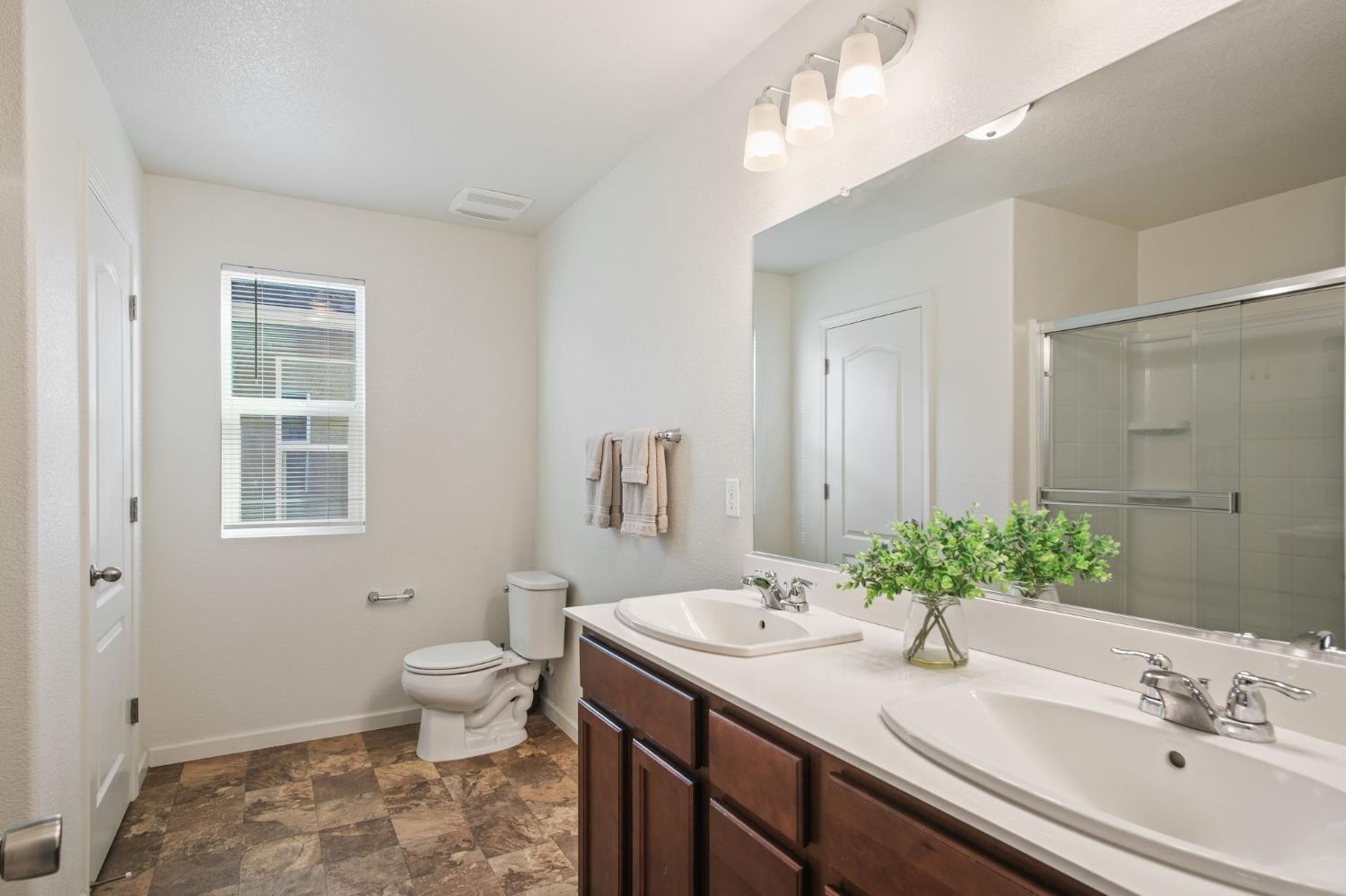 767 Day Break Way Ceres, CA 95307 - Photo 21 of 28 a bathroom with a granite countertop sink a toilet and a mirror