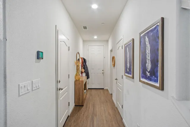 a view of a hallway with wooden floor and entryway