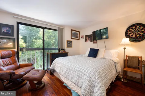 a bedroom with a bed a couch and a large window