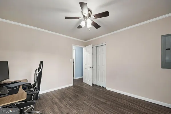 a view of workspace with wooden floor and fan