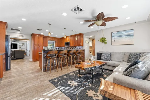 a kitchen with stainless steel appliances granite countertop a stove top oven a sink a dining table and chairs