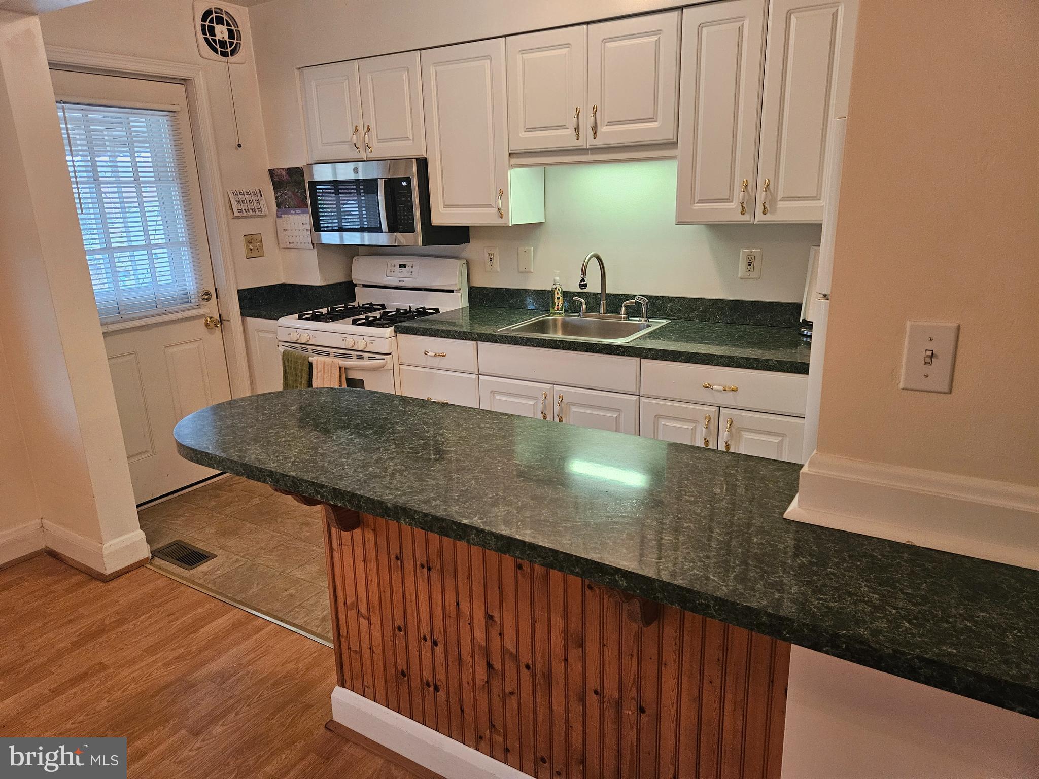 6907 Belclare Road Baltimore, MD 21222 - Photo 4 of 26 a kitchen with stainless steel appliances granite countertop a sink a stove and a microwave