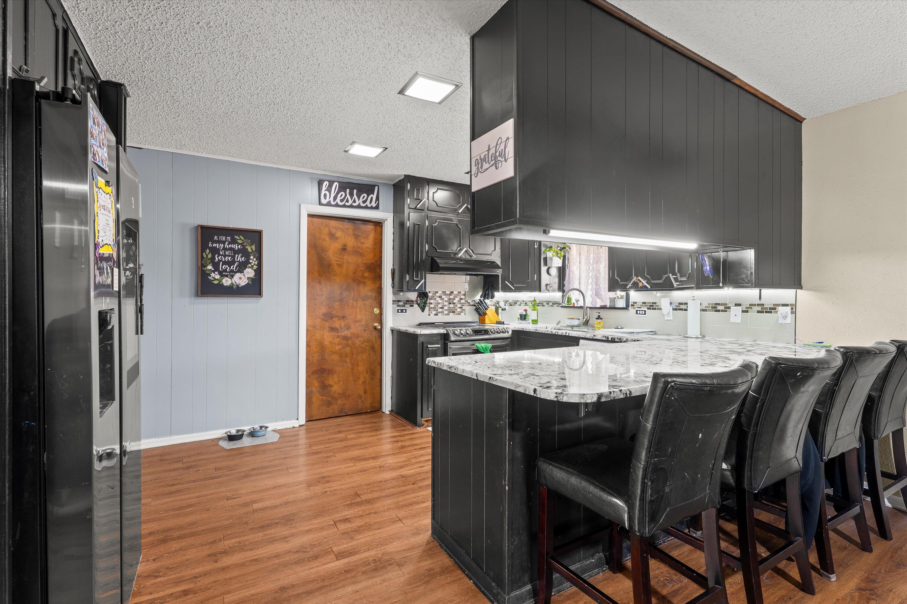 403 Crescent Drive Littlefield, TX 79339 - Photo 12 of 35 a kitchen with stainless steel appliances kitchen island granite countertop a refrigerator and a stove top oven