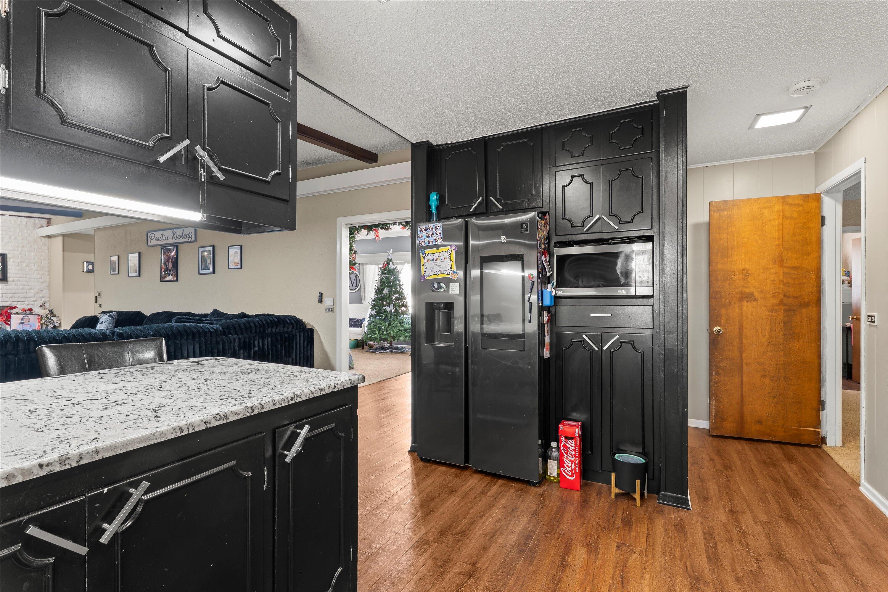 403 Crescent Drive Littlefield, TX 79339 - Photo 14 of 35 a kitchen with stainless steel appliances granite countertop a refrigerator a sink and wooden floor