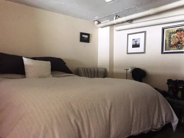 a bedroom with a bed and a painting on the wall