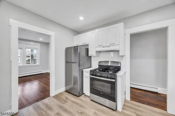 a kitchen with white cabinets and stainless steel appliances