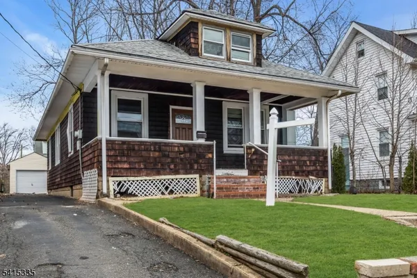 a front view of a house with a garden and yard