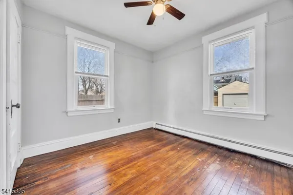 a view of empty room with wooden floor and window