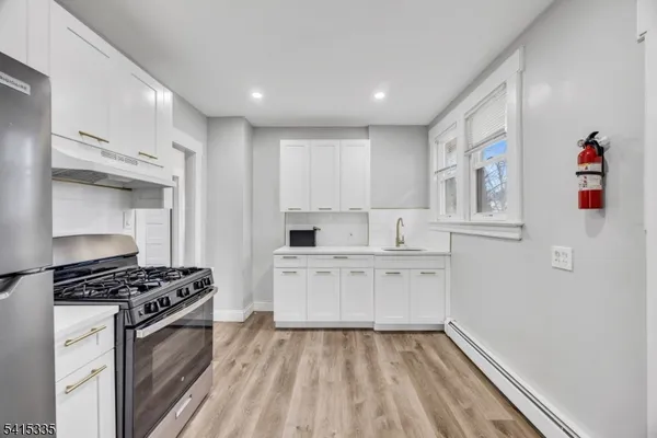 a kitchen with cabinets appliances and a window