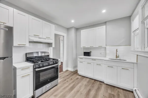 a kitchen with cabinets appliances and a window