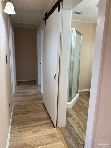 a view of a hallway with wooden floor and staircase