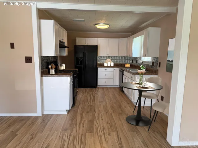 a kitchen with a refrigerator a stove cabinets and wooden floor