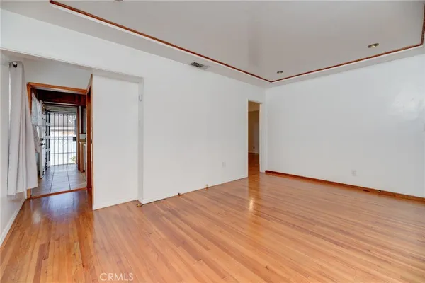 a view of an empty room with wooden floor