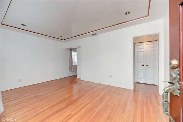 a view of an empty room with wooden floor