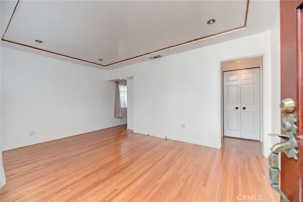 a view of an empty room with wooden floor