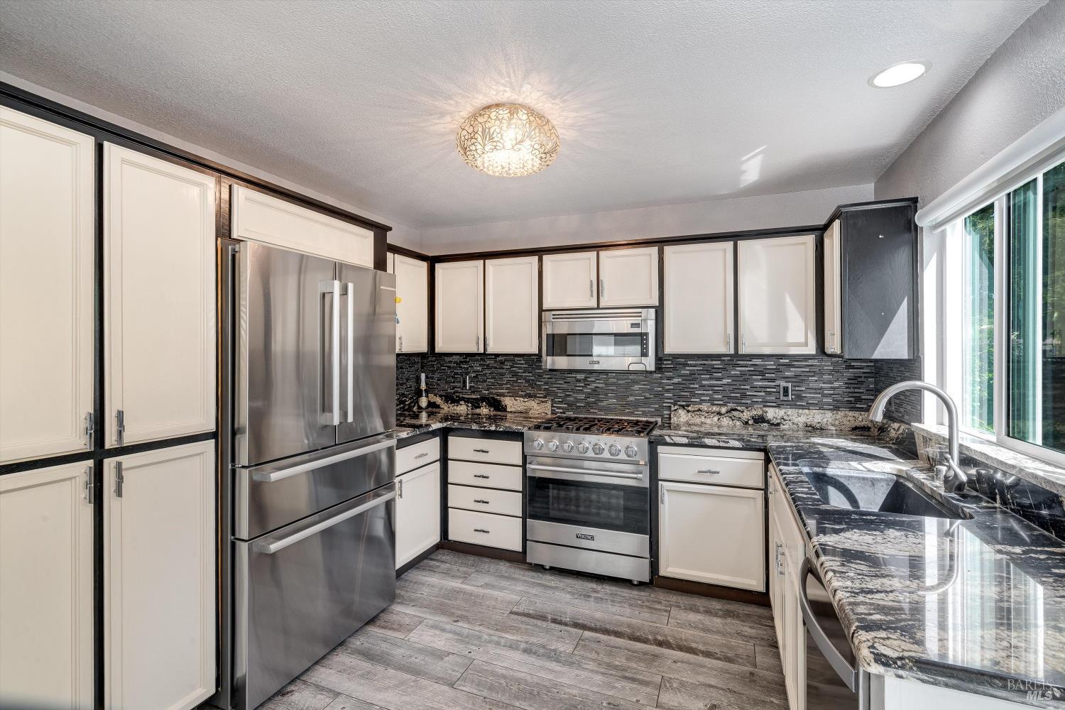 187 Wikiup Meadows Drive Santa Rosa, CA 95403 - Photo 22 of 66 a kitchen with stainless steel appliances granite countertop a stove refrigerator and cabinets