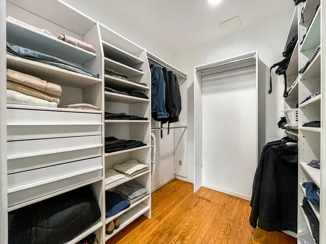 a view of walk in closet with clothes and shoes