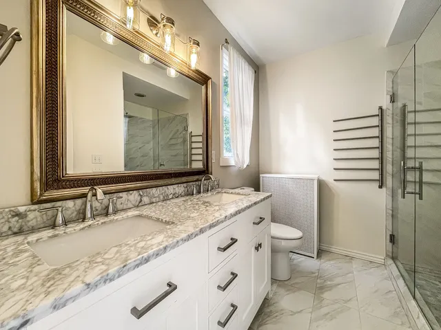 a bathroom with a granite countertop sink mirror vanity and toilet