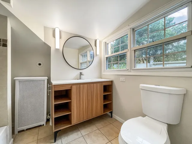 a bathroom with a toilet a sink and a mirror