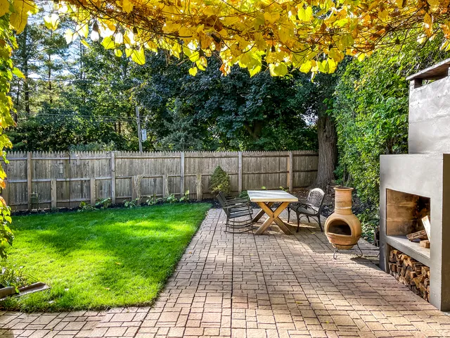 a backyard of a house with table and chairs